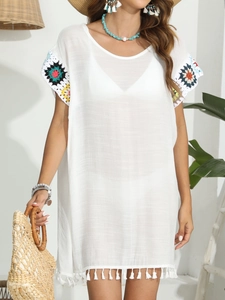 Détail de tunique de plage blanche avec poignets en crochet coloré et franges
