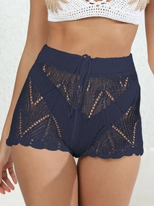Dettaglio ravvicinato dei pantaloncini da spiaggia in crochet blu navy traforati