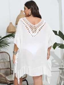 Detail of white crochet hollow-out back on loose beach cover-up with ruffle trim