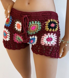Close-up of handmade crochet beach shorts with colorful granny square patterns and drawstrings