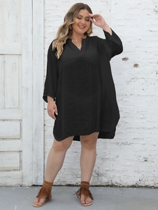 Close-up of black plus size V-neck dress featuring long sleeves and pleated texture fabric