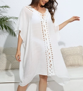 Detailed close-up of white crochet hollow-out lace patterns on a bohemian beach cover-up