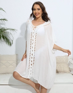 Detail of white chiffon beach cover-up with crochet lace stitching and V-neckline design