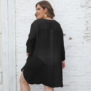 Detail view of black oversized beach cover-up shirt with textured fabric and curved hem