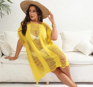 Detail of yellow crochet beach cover-up with hollow-out knit and bohemian tassel fringe