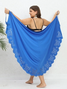 Detail of royal blue beach cover-up featuring laser-cut butterfly and floral lace hem