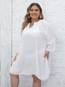 Detail of white semi-sheer beach cover-up featuring side slits and textured fabric