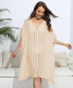 Detailed close-up of beige crochet lace stitching on a loose V-neck beach cover-up dress