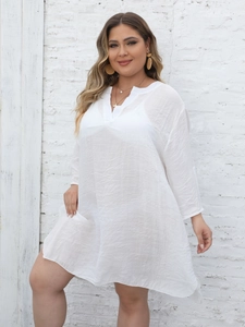 Detail view of the lightweight woven fabric and adjustable buttoned sleeves of white V-neck tunic