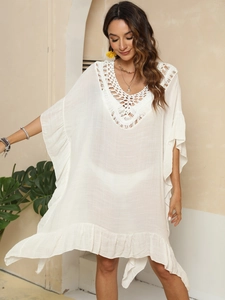 Détail de la robe de plage bohème en crochet blanc avec décolleté en V et volants