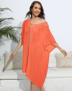 Detail of orange beach cover-up featuring intricate crochet neckline and boho knit texture