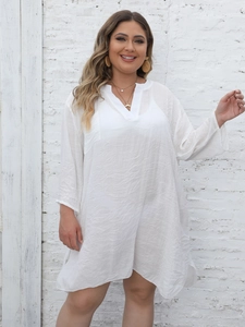 Close-up of lightweight white textured fabric on a loose V-neck beach cover-up dress