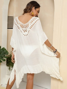 Détail du dos en crochet blanc ajouré et ourlet à volants sur la robe de plage