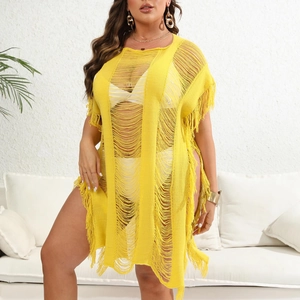 Close-up of bright yellow knit beach cover-up featuring fringe tassels and hollow texture