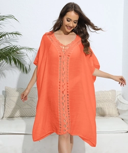 Macro detail of vibrant orange beach cover-up with intricate crochet knit neckline