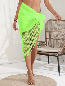 Detail of neon green mesh beach sarong featuring fringe edges and a waist tie closure