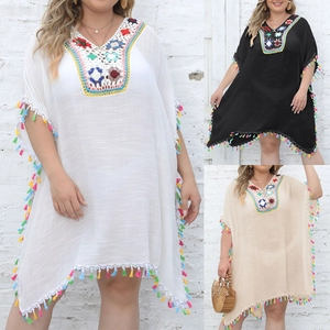 Detailed close-up of colorful crochet neckline and fringe on bohemian beach cover-up dress
