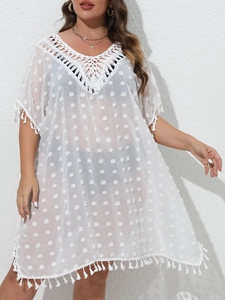 Détail du haut de plage blanc avec décolleté en crochet et détails de pompons