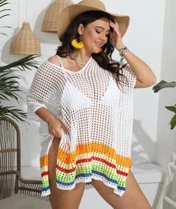 Detail of white crochet beach cover-up with vibrant rainbow stripes and knit texture