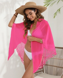 Macro shot of rose pink beach sarong featuring intricate crochet hollow-out and tassel trim