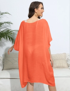 Detail of loose orange beach cover up showing breathable sheer striped fabric and relaxed fit