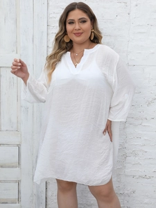Detail of white oversized beach cover-up featuring V-neckline and adjustable tab sleeves
