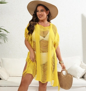 Detail of yellow knit beach cover-up dress featuring cutout patterns and long fringe tassels