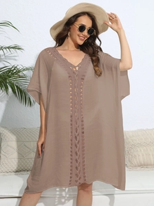 Detail of deep V-neckline with hollow crochet stitching on women's beach cover-up dress