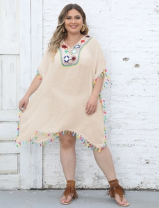 Detail of colorful crochet neckline and vibrant tassels on a beige plus size beach cover-up