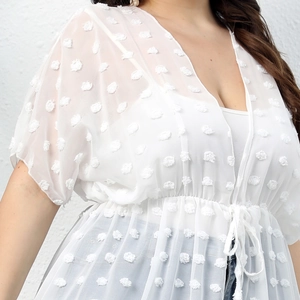 Detailed view of white Swiss dot chiffon fabric and waist drawstring on beach cover-up
