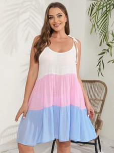 Detail of color-block tiered dress featuring adjustable bow straps and breathable fabric