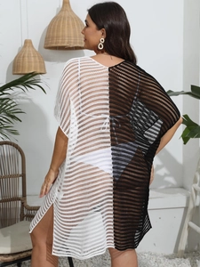 Détail de la robe en maille crochetée avec patchwork noir et blanc et fente latérale