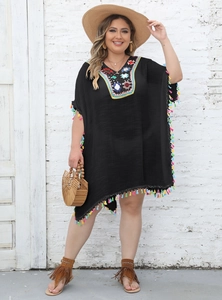 Detail of colorful crochet neckline and rainbow tassels on a black plus-size beach dress