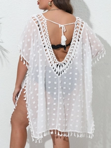 Détail de la tunique de plage blanche à pois suisses avec dentelle au crochet et pompons