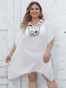 Detail of colorful crochet V-neckline and vibrant fringe on white beach dress cover-up