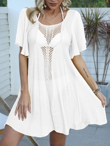 Close-up of white crochet beach cover-up featuring geometric mesh V-neck and hollow details