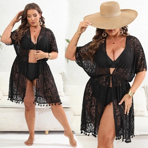 Detail of black crochet lace cover-up with tassel edges and bikini beachwear set