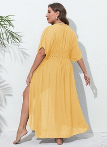 Detail of bohemian yellow beach cover-up featuring intricate crochet lace at the waist