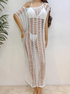 Detailed macro view of the white crochet knit pattern and hollow striped texture of the dress