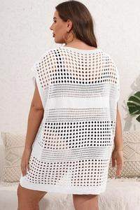 Macro shot of white hollow crochet knit fabric on a loose bohemian beach cover-up dress