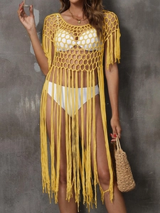 Detail of yellow crochet beach cover-up with hollow knit texture and long fringe tassels