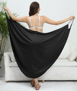 Detalle del vestido de playa cruzado negro en tejido sedoso mostrado por una modelo