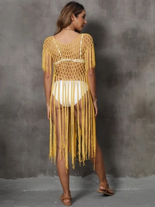 Detail of yellow hollow-out crochet beach cover-up with long tassel fringe on the hemline