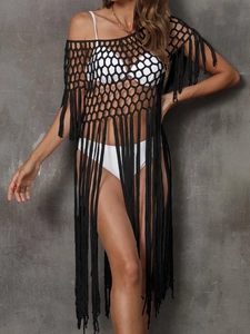 Detail of black crochet beach cover-up featuring honeycomb mesh and long fringe tassels