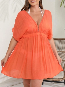 Detail eines orangen Maxi-Kleids mit tiefem V-Ausschnitt und strukturierter Taille
