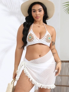 Close-up of handmade crochet bikini top with sunflower embroidery and fringe skirt