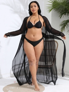 Detail of sheer black mesh long cardigan cover-up over bikini showing fabric texture