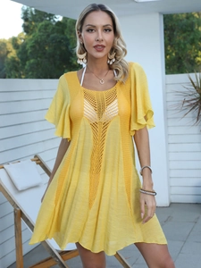 Detail of yellow beach cover-up featuring intricate crochet neckline and ruffled sleeves