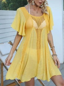 Detail of yellow beach cover-up featuring hollow crochet knit and flared sleeves
