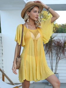 Detailed view of yellow crochet beach cover-up featuring openwork stitch and wavy hem